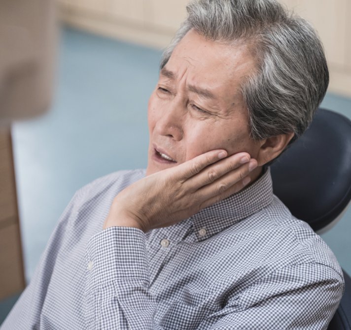 잇몸 통증으로 볼을 감싼 어르신